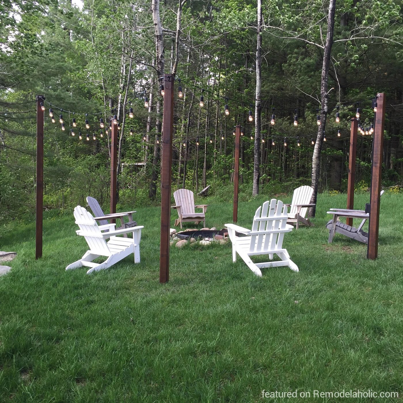 Handmade straightforward outdoor string lighting posts around a fire pit and seating area, featured on @Bekob wm