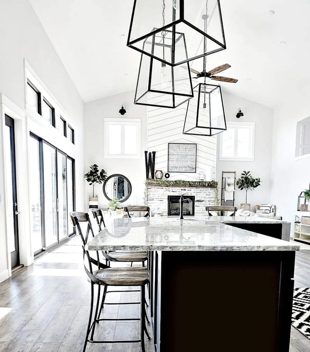White And Black Kitchen With Wood Paneling Metal And Glass Light Fixtures And Wood Foors