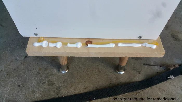 squeeze a small layer of construction adhesive onto the board and place the unit atop the board, clamp into place