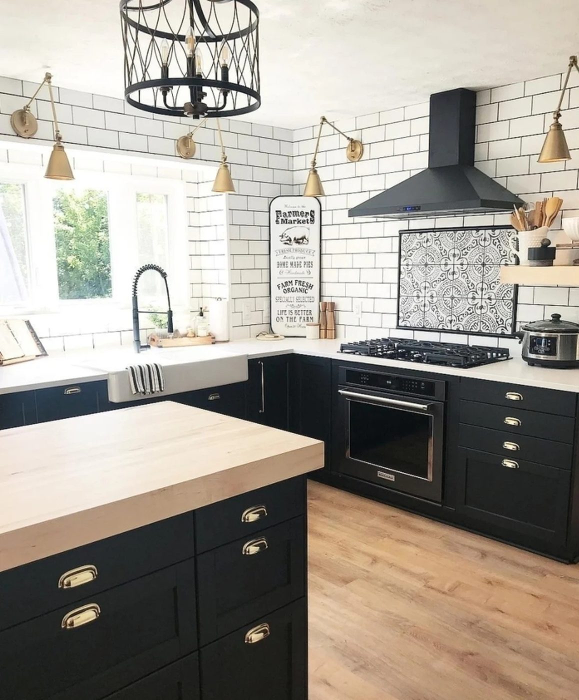 Black Cabinet And Light Natural Wood Countertop Kitchen With White Brick Walls And Gold Furnishings