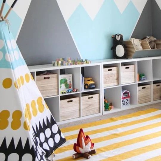 Playroom With Striped Yellow Rug, Colorfull TeePee And Square Cubbies With Mountains On Wall