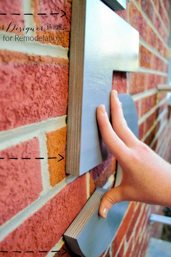 hanging large house numbers on brick