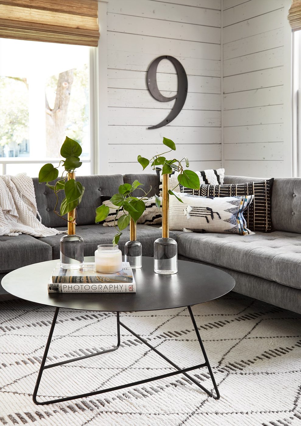 Get This Look: Fixer Upper Living Room from The Americana House | Recreate the iconic Joanna Gaines modern farmhouse chic style from the shiplap and neutral area rug to the chandel