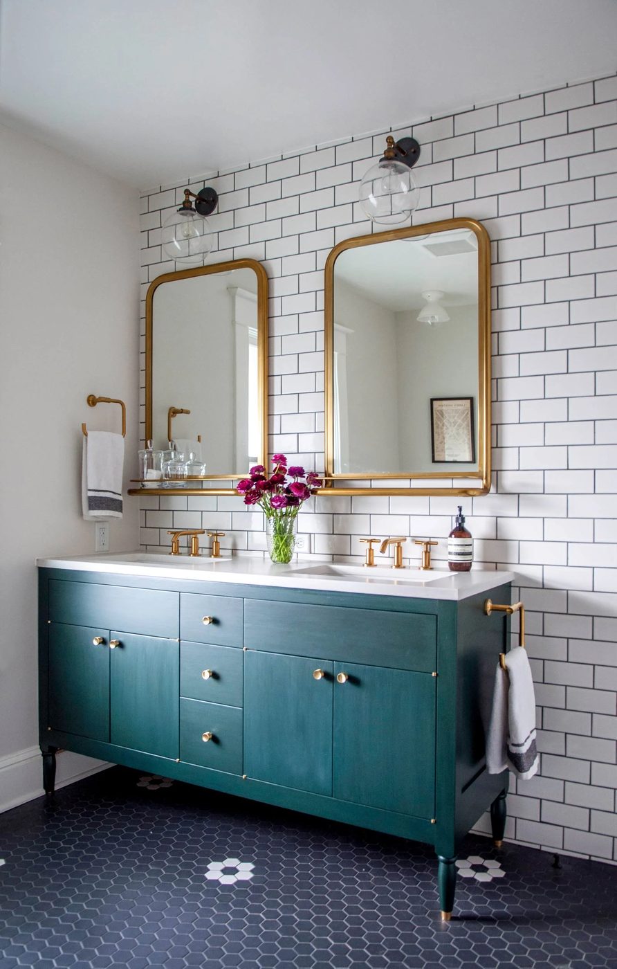 bathroom remodel with gold mirrors and faucets, schoolhouse lighting, dark vanity, subway tile Hammer and Hand