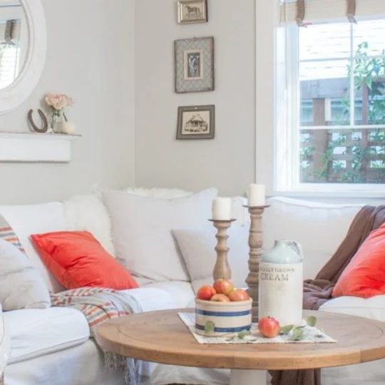 White And Grey Room With Wood Circle Table And Wood Candlesticks And Red Accents