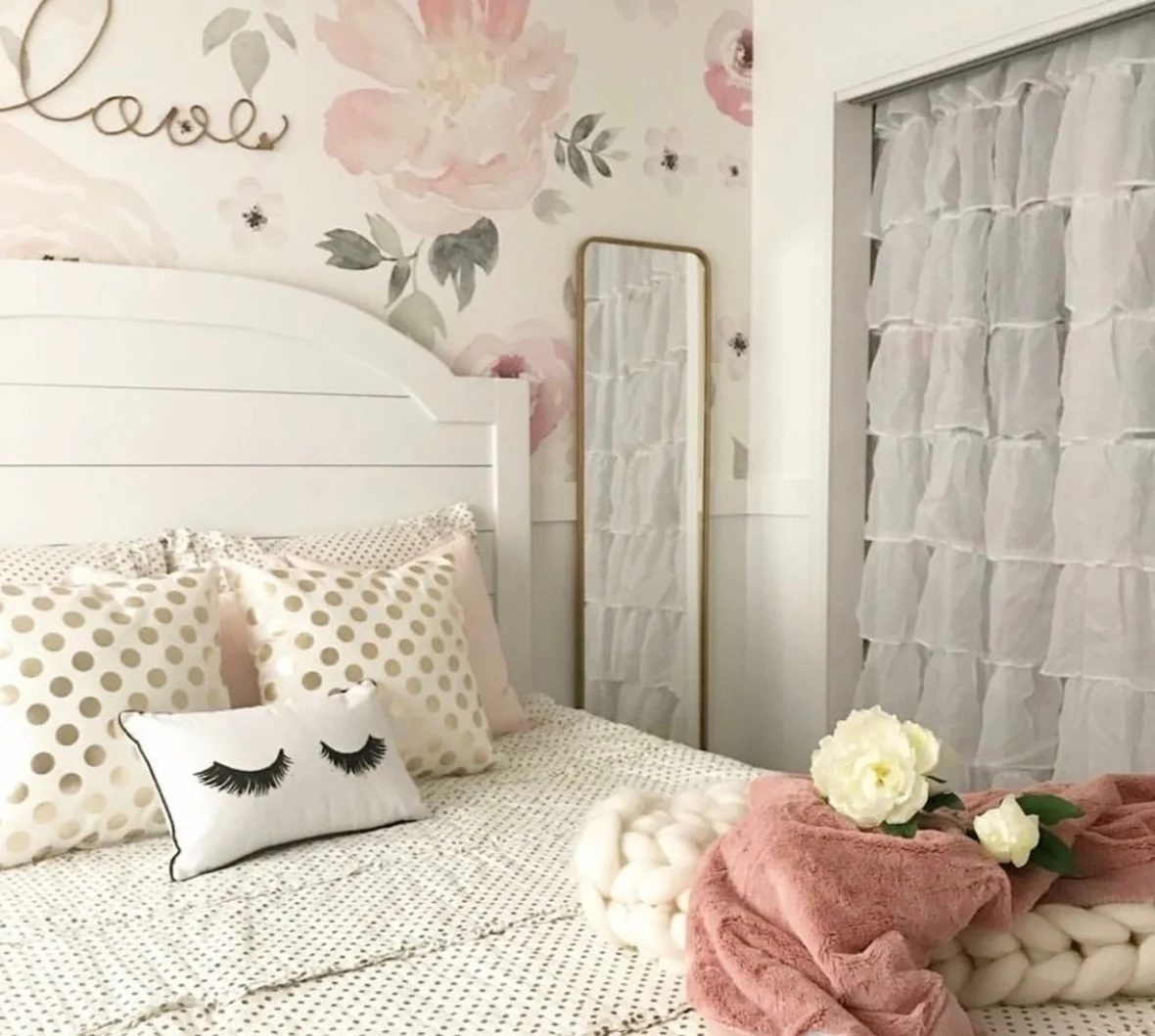 White Bed With FLoral Accent Wall And White Curtained Closet And Blush Accents