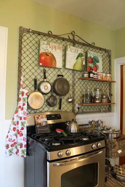 kitchen organized wall using an old gate to hang pans and spices
