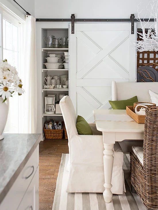 farmhouse dining room in neutrals with a sliding barn door via BHG