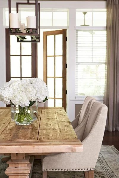 farmhouse dining room with swoop arm chairs and rustic wood table by Linda McDonald Design