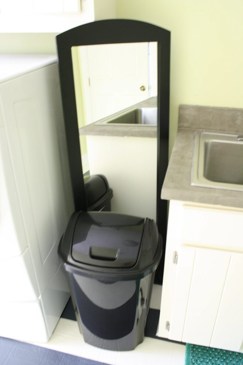 use a tall mirror to hide laundry room plumbing fixtures, featured on Bekob