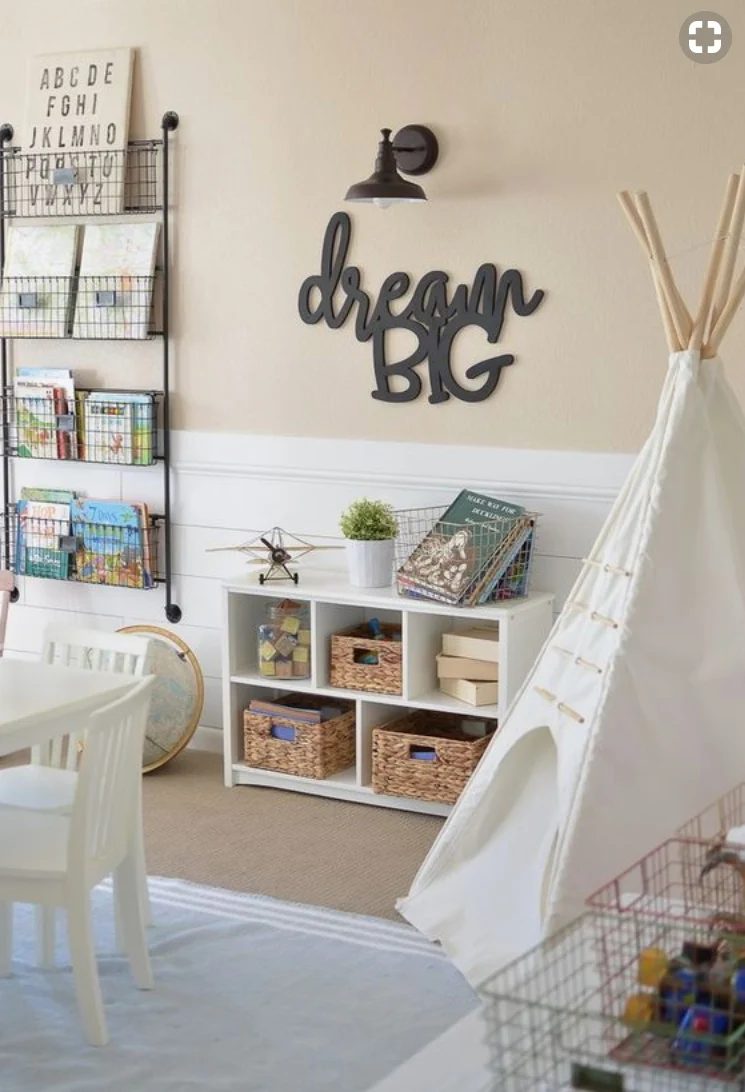Play Room With Hanging Metal Baskets Full Od Books, White Bookshelf With Baskets And Blocks, And A Teepee And White Table