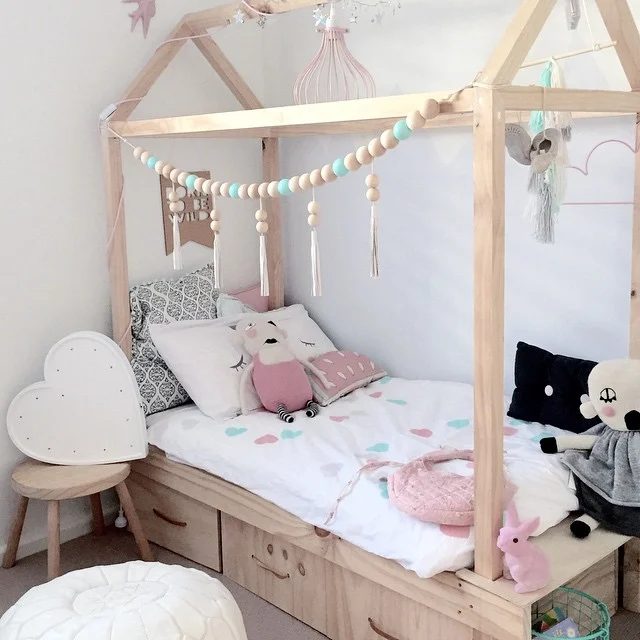 cute little girls room -- kids house bed with storage drawers underneath and a wood bead garland via mintinteriordesign