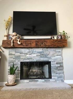 Grey Brick Fireplace Topped With A Rustic Wood Shelf