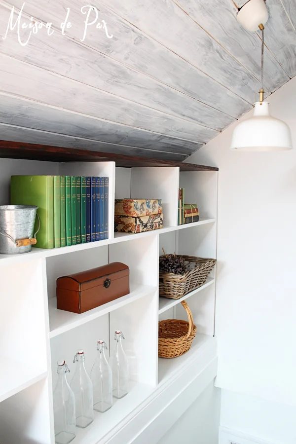 Whitewashed attic ceiling with built-in shelving along stairs - Maison de Pax on Bekob.com