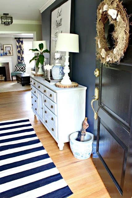 The navy wall in this foyer is vivid! And the wood slice under the lamps is a fun rustic touch to a more traditional space. | 100+ striking Mudrooms and Entryways at Bekob.com