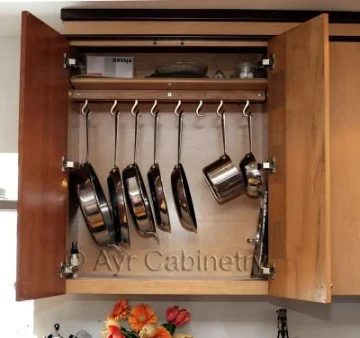 Open Stained Wooden Cupboard With Hanging Stainless Still Pots And Pans
