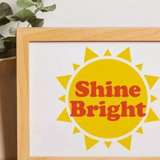 Wooden Frame With Yellow Sun Image And Shine Bright Wording Across The Sun