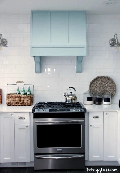 The Happy Housie white kitchen and blue range hood with corbels