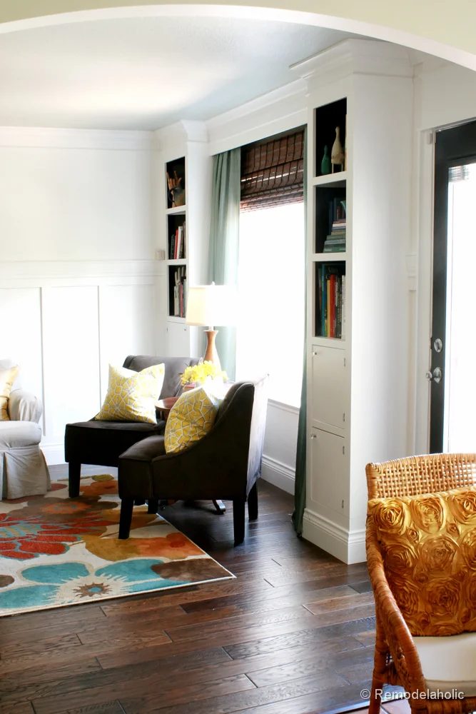Living Room Remodel with yellow accents wood floors and built-in bookcases and columns with arches-13