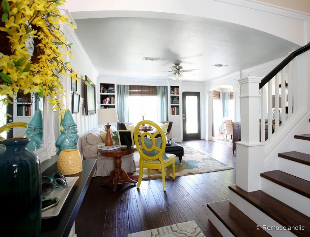 Living Room Remodel with yellow accents wood floors and built-in bookcases and columns with arches-3