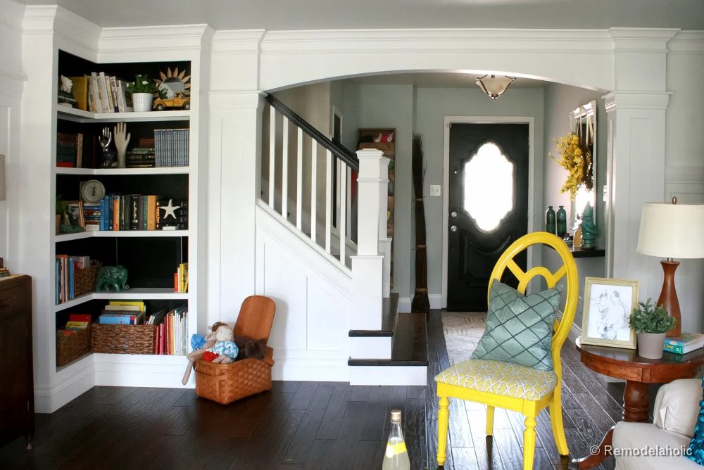 Living Room Remodel with yellow accents wood floors and built-in bookcases and columns with arches-24