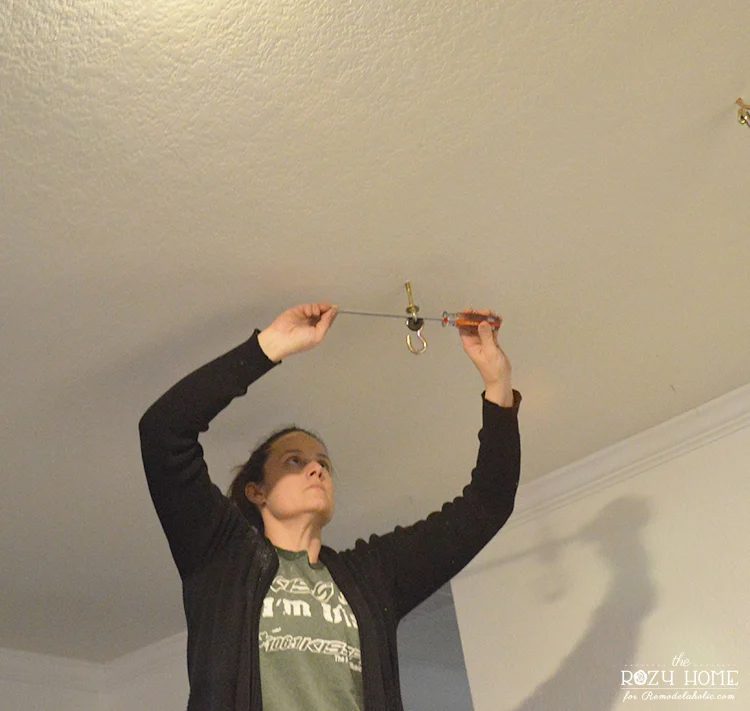 Installing a Handmade swing for kids indoor swingset - use screwdriver to tighten swing hardware to ceiling