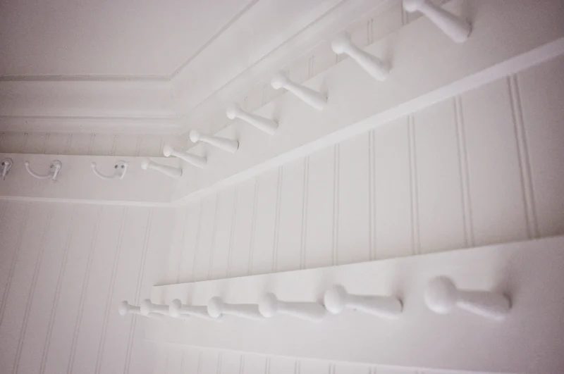 hall closet organization option - pegs to hold winter boots and shoes, hung above the door