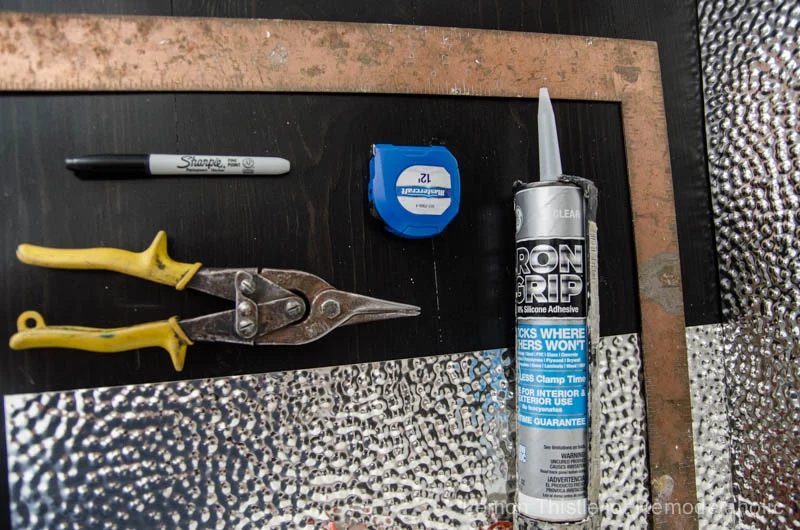 Learn how to install a unique and modern (but straightforward to clean!) metal ceiling tile backsplash. Tip #1: It's all about using the right adhesive!