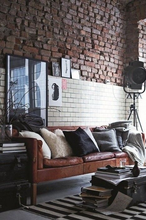 Two styles of brick on the wall, plus a leather sofa