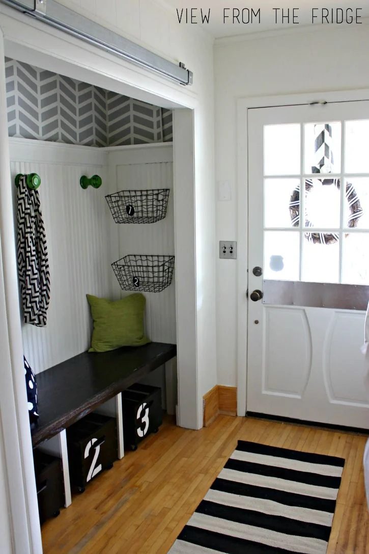 I really like the mix of patterns in this black and white entry. well fitted storage bench with rolling bins!