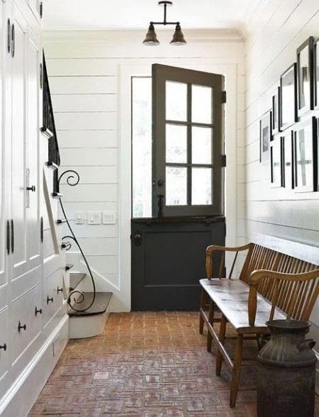 A black Dutch door and exposed brick in the entryway. Add this to my dream home list! and look at all that storage under the stairs!