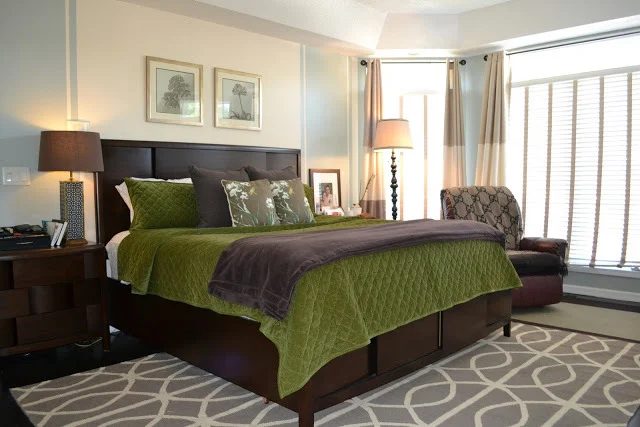 Bedroom With Large Window And Dark Wood Headboard And Frame And Nighstands With Green And Brown Bedding And Dark Leather Rocker Recliner