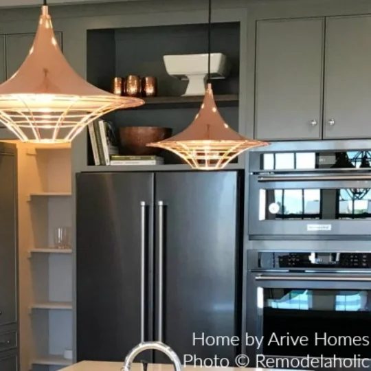 Green And Black Kitchen With Unique Light Fixures