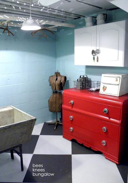 striking turquoise and red organized laundry room with storage