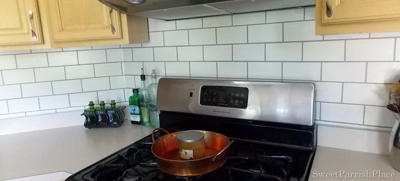 stove with faux painted subway tile backsplash