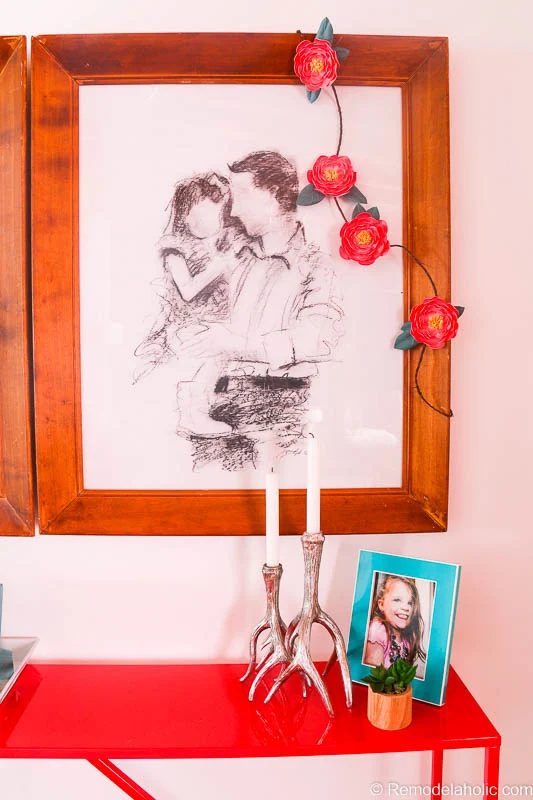This striking paper flower garland looks strong draped over artistic family portraits in wood frames. Great for party decor or anywhere you need a little color. Free printable from