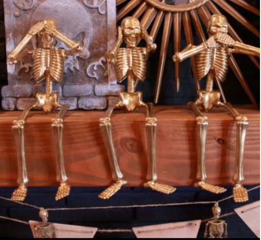Gold Skeletons From The Dollar Store On Wood Mantel