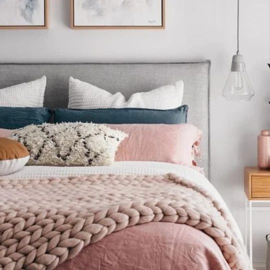 Bedroom With White Walls, Grey Headboard, Pink Comforter And Pillows With Blue And White Accents