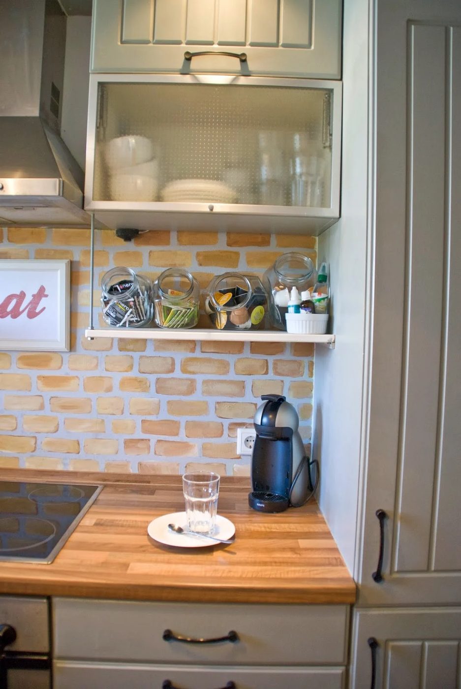 open shelf beneath cabinets with brick backsplash and butcherblock countertops - Pudel-design featured on @Bekob