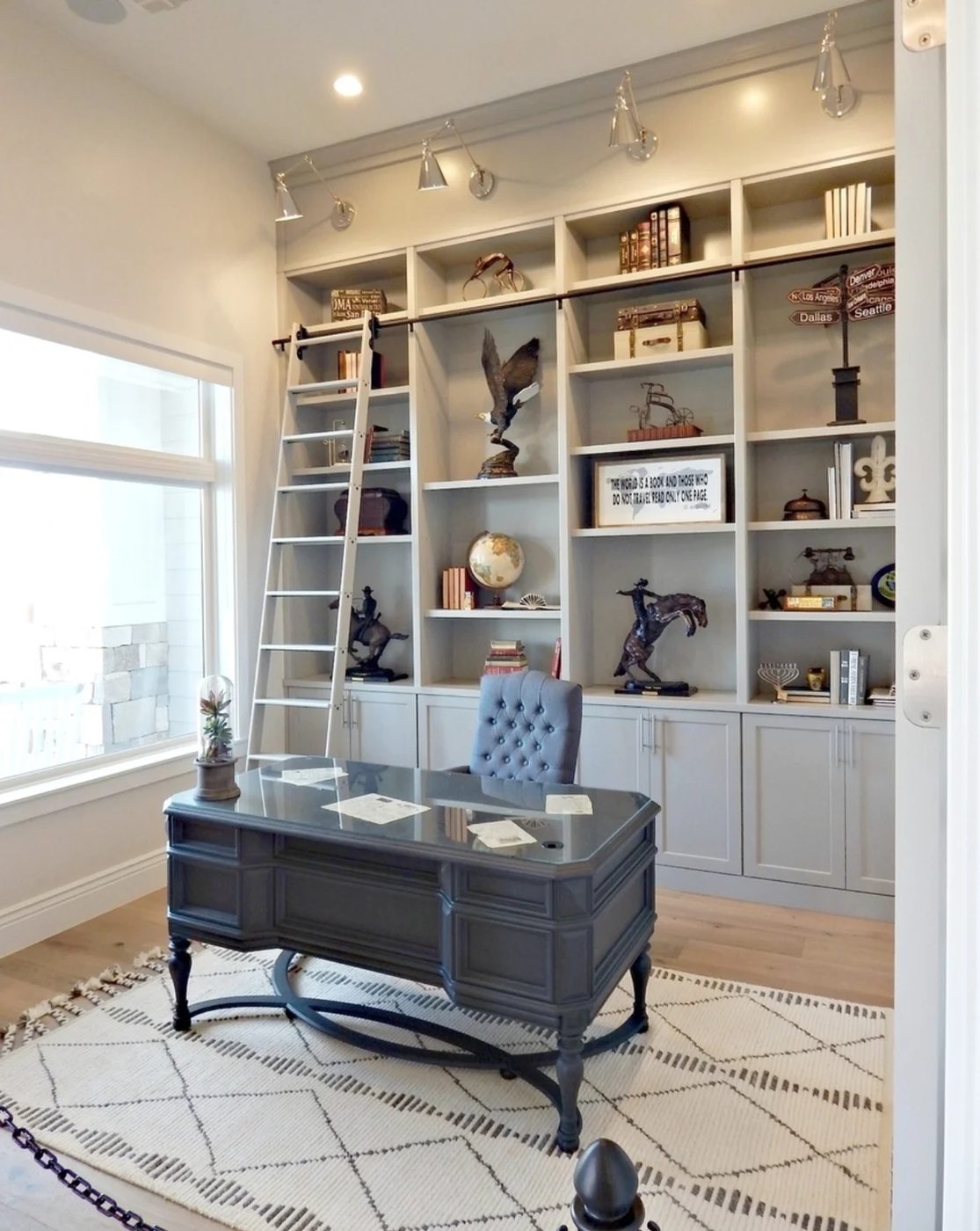 White Office With Grey Bookshelves And Cabinets With A Rolling Ladder, Black Desk And White And Black Rug
