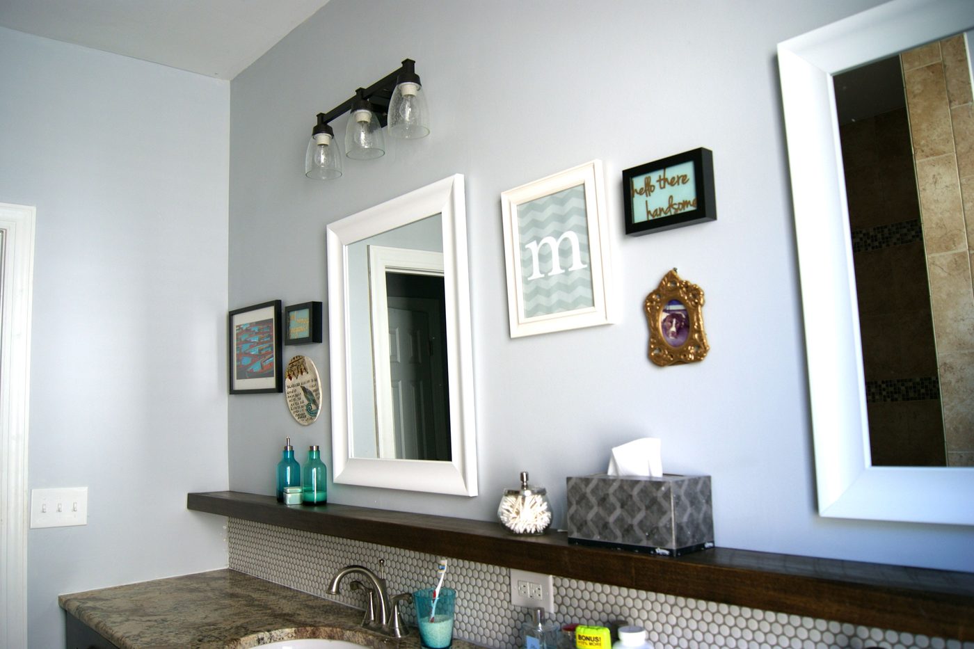 Handmade bathroom makeover, framed white mirrors, floating wood shelf, penny tile, painted gray