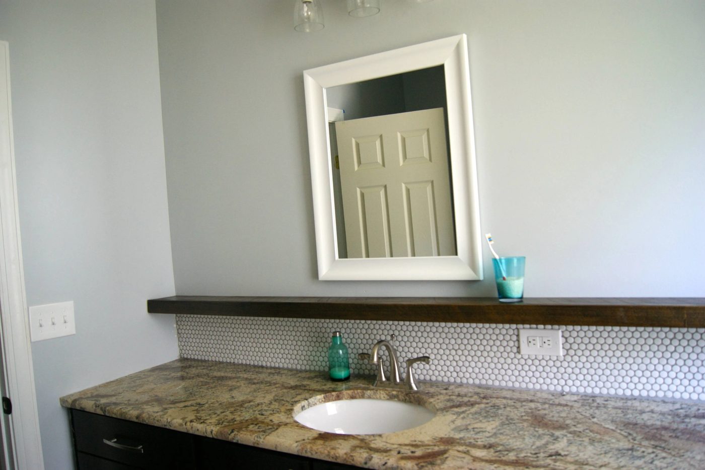 bathroom makeover with penny tile and floating wood shelf
