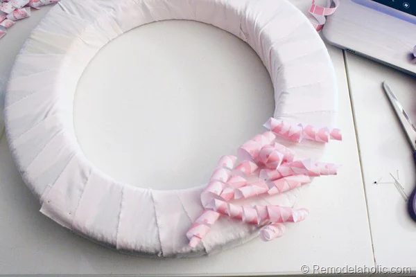 Using straight pins apply paper curls to form for a pretty look