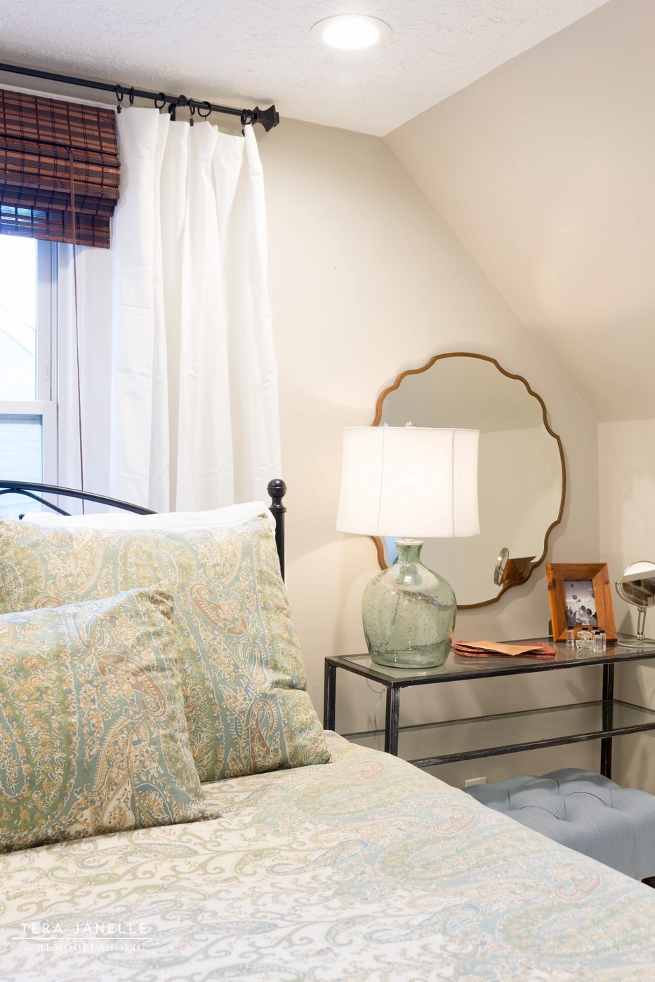 A striking travel-inspired master bedroom with an exposed brick wall and a striking built-in bookshelf and storage nook. Tera Janelle on Bekob.com