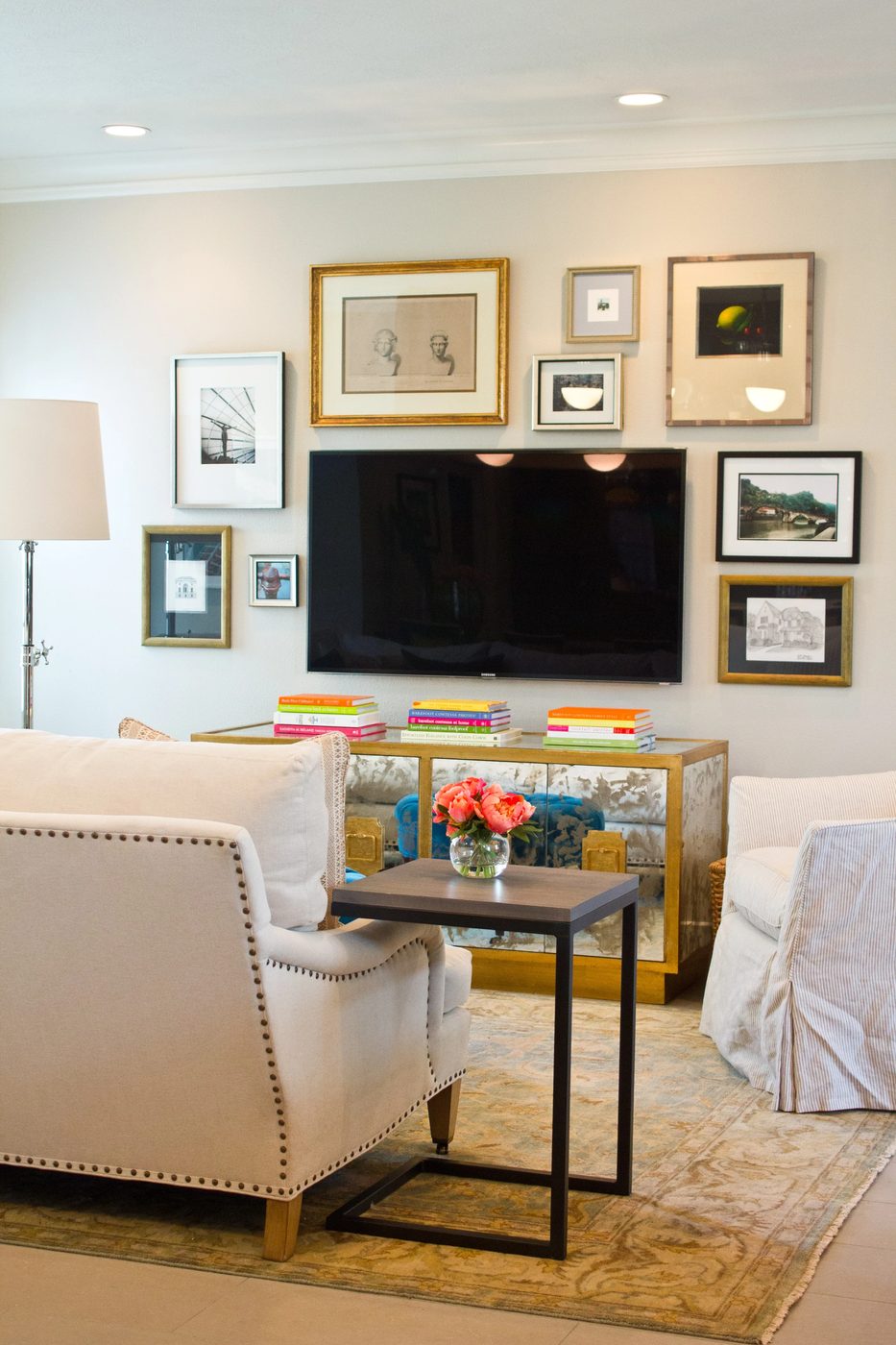 balanced gallery wall with gold frames around TV (via Material Girls)