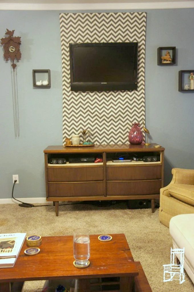 hide TV cables with a fabric panel behind a wall-mounted TV (thefrontpoarch)