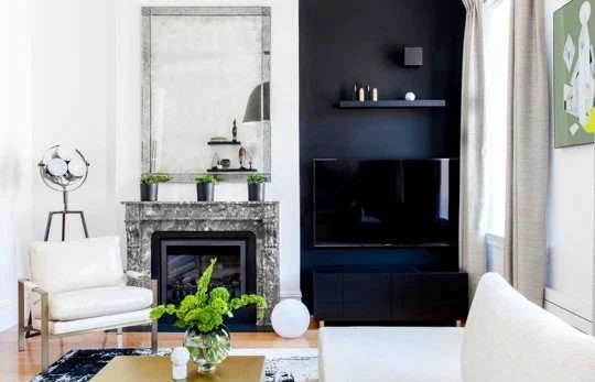 hide the TV on a painted black wall or bookshelf (via Apartment Therapy)