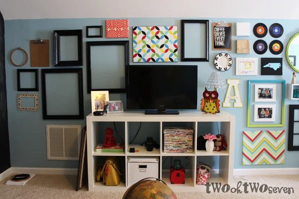 television as part of a long gallery wall in a family room - use empty frames and other elements (via twoohtwoseven)