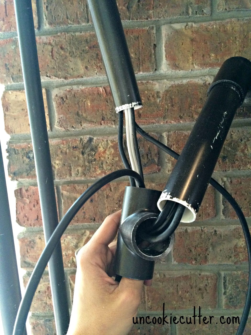 hide television cords in faux pipe shelving as entertainment center (UncookieCutter)