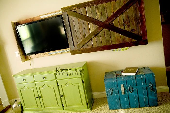 handmade sliding barn door cover to hide the television (Kristen Duke Photography)